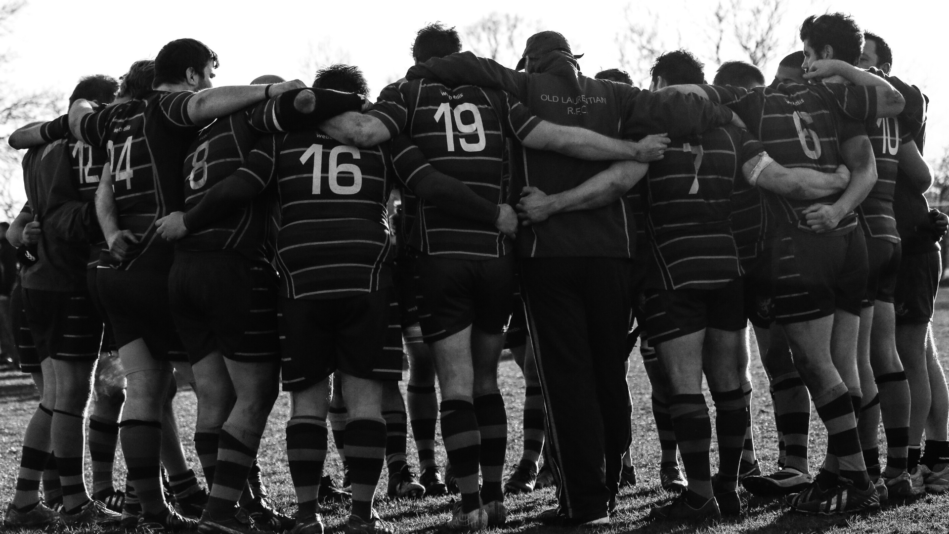 Show a rugby team in a huddle